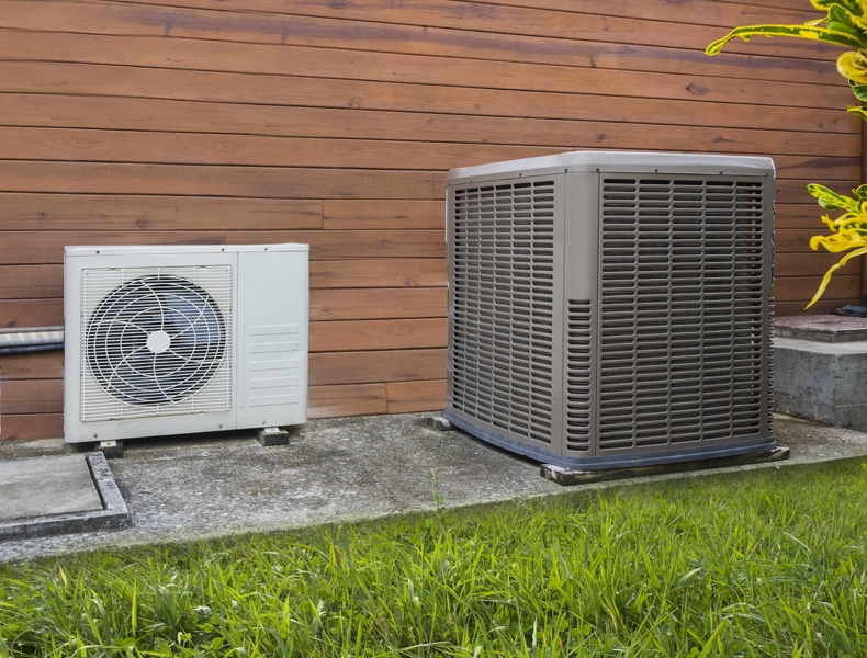 Blog Title: What Is a Heat Pump? Photo: Air conditioning heat pumps on the side of a house